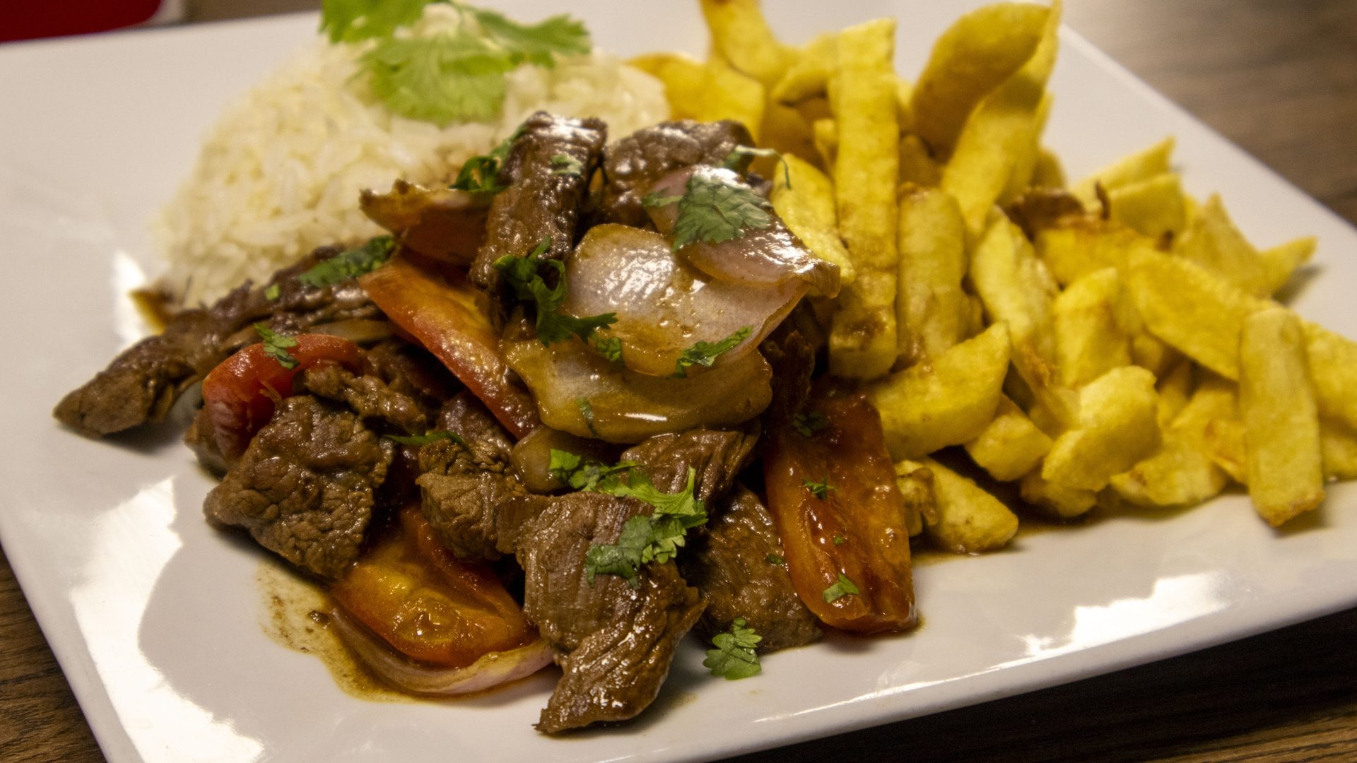 Lomo saltado a lo pobre: lomo, papas, arroz, huevo frito y plátanos
